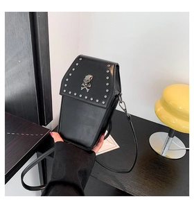 Detailed view of coffin shaped gothic crossbody bag with silver skull and stud accents