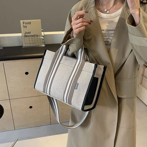 Detail shot of canvas tote bag with brown striped webbing and SJCH letter logo