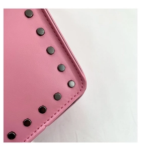 Detail of pink leather bag with black metal rivets and fine stitching craftsmanship