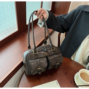 Close-up of vintage faux leather bowling bag with gold hardware and dual front pockets