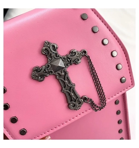 Detail of pink gothic bag featuring a vintage metal cross, fine chains and black rivets