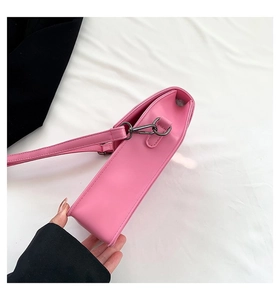 Pink crossbody bag detail showing bottom thickness and gun-black metal buckle hardware