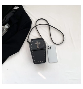 Detail view of coffin-shaped gothic bag featuring metal cross and silver stud rivets