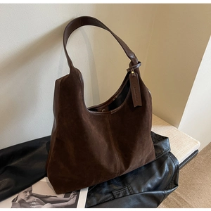 Macro view of stitching on brown suede tote bag with Smile & Fashion hanging tag