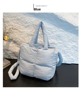 Détail du sac matelassé bleu clair avec coutures carrées et texture douce et rembourrée