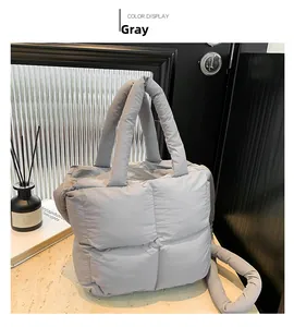 Détail du sac bandoulière matelassé gris avec poignée rembourrée et texture à carreaux