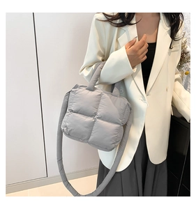 Gros plan du sac à bandoulière matelassé gris clair avec grandes coutures carrées