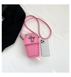 Detailed macro view of pink coffin-shaped gothic crossbody bag with silver cross and studs