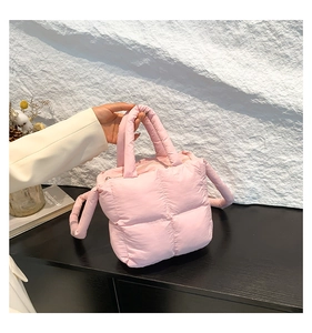 Détail du sac à main matelassé rose avec texture moelleuse et poignée rembourrée