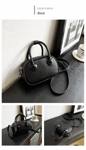 Dettaglio di una mini borsa Boston nera con stampa coccodrillo e cerniere in metallo argento