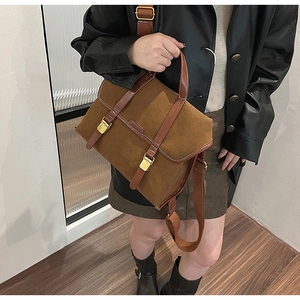Close-up of vintage brown frosted messenger bag with leather straps and golden buckles