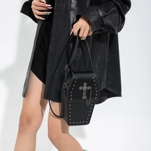 Gothic black coffin-shaped shoulder bag with silver studs and cross on white background