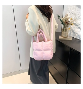 Sac à main matelassé rose moderne porté par un mannequin dans un cadre élégant
