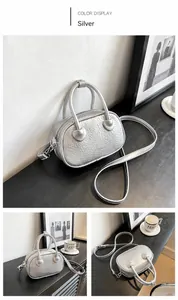 Dettagli di una borsa a mano argento con texture, doppi manici e logo di moda