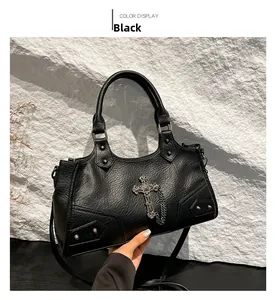 Detail of gothic black tote bag featuring silver cross pendant and rivet textures