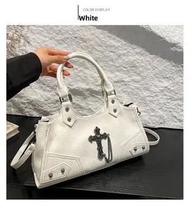 Close-up of white punk tote with metallic cross pendant and studded leather texture