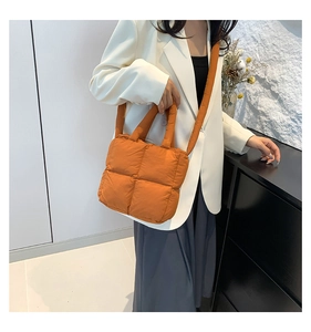 Vue détaillée du sac cabas matelassé orange avec bandoulière large sur un mannequin
