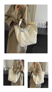 Detailed macro view of cream pleated canvas tote bag fabric and small letter label