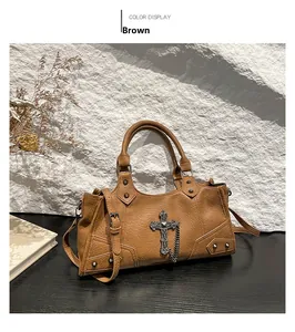 Close-up of brown vintage PU bag with metal cross charms, silver chains and rivets