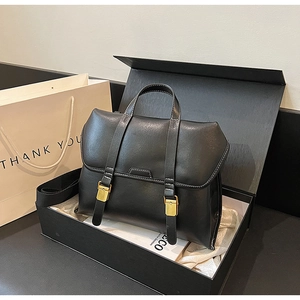 Detail of a black matte vintage briefcase bag in a gift box with golden hardware details