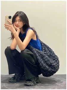 Mirror selfie showing the large black quilted cloud bag with puffy bubble texture for women