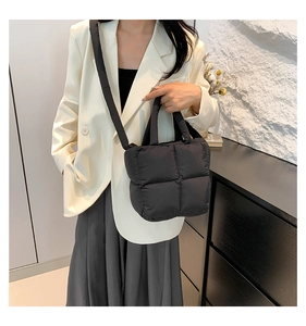 Détail du sac bandoulière noir matelassé en coton avec sangle réglable sur mannequin