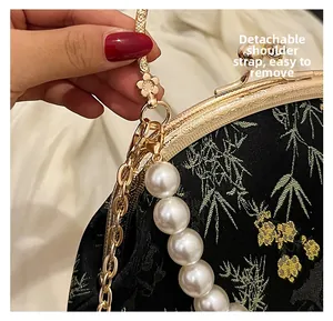 Detalle de la correa de perlas desmontable y el cierre dorado del bolso bordado chino