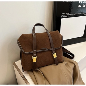 Macro detail of dark brown frosted vintage satchel showing fine stitching and gold buckle