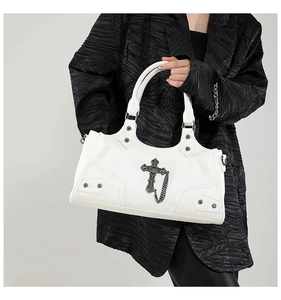 Detail of white leather motorcycle bag with silver crosses, rivets and chain decor