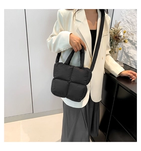 Gros plan du sac matelassé noir avec poignée rembourrée souple et texture en nylon