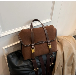 Detail of vintage dark brown frosted leather backpack with antique gold hardware
