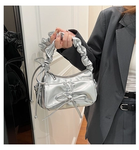 Détail d'un sac à main argenté en cuir PU plissé avec nœud et poignée froncée