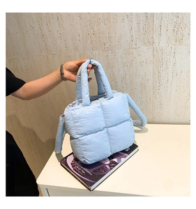 Détail du sac cabas matelassé bleu clair avec texture douce en duvet et poignées épaisses