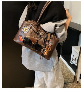 Détail d'un sac cabas vintage marron avec des patchs rétro et lunettes décoratives