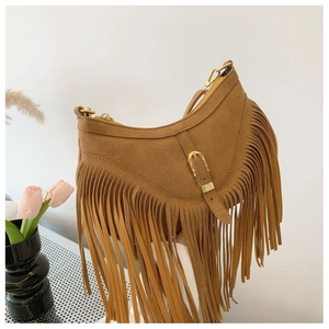 Détail du sac à bandoulière en daim marron avec franges bohèmes et boucles dorées