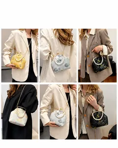 Detalle del bolso bordado con flores vintage, asa de perlas y cadena metálica fina