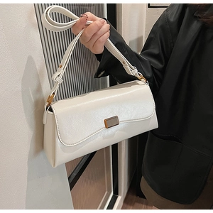 Detail of white rectangle underarm bag with cracked texture and gold buckle decoration
