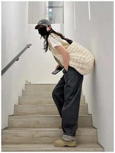 Quilted cloud shoulder bag in ivory white shown on model in a minimalist setting