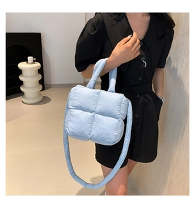 Détail d'un sac à bandoulière matelassé bleu clair avec motif à carreaux doux