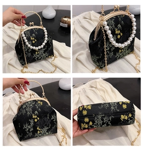 Vista detallada de bolso bordado oriental con bambú dorado y asa de perlas