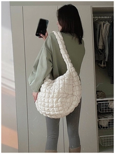 Large white puffer cloud bag with quilted pleats shown in a casual lifestyle mirror selfie