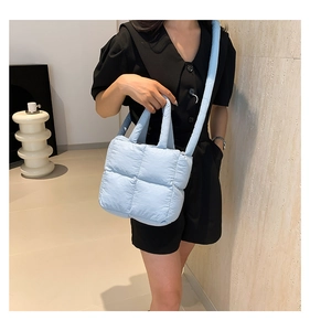 Détail du sac matelassé bleu clair montrant la texture douce et les coutures carrées