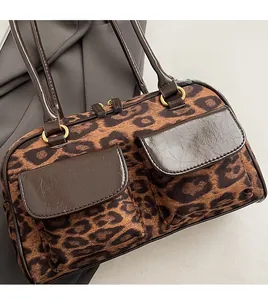 Close-up of leopard print handbag featuring brown cracked leather flap and gold hardware