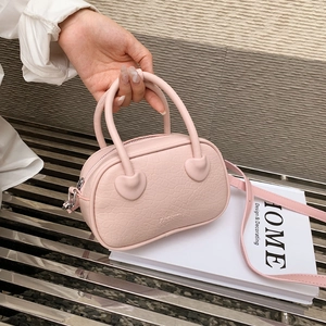 Dettaglio borsa rosa effetto coccodrillo con toppe a cuore e scritta fashion incisa sopra