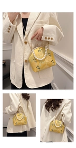 Detalle del bolso jacquard amarillo con elegante asa de perlas y cadena dorada