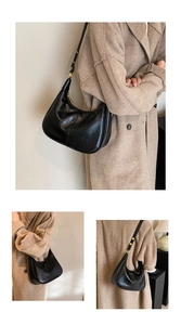 Detail of black hobo bag with vintage leather texture and adjustable gold hardware