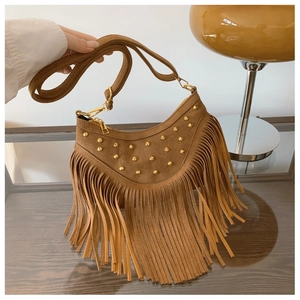Détails d'un sac en daim marron avec franges, rivets dorés et finitions métalliques