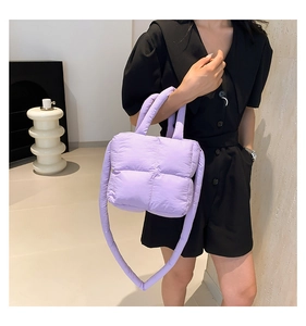 Sac matelassé violet clair porté par un mannequin avec détails de la bandoulière