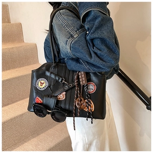 Détail du cabas vintage noir avec écussons rétro et accessoire en forme de chocolat