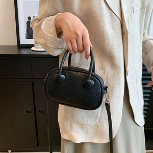 Dettaglio borsa nera in pelle PU a grana litchi con scritta FASHION in rilievo